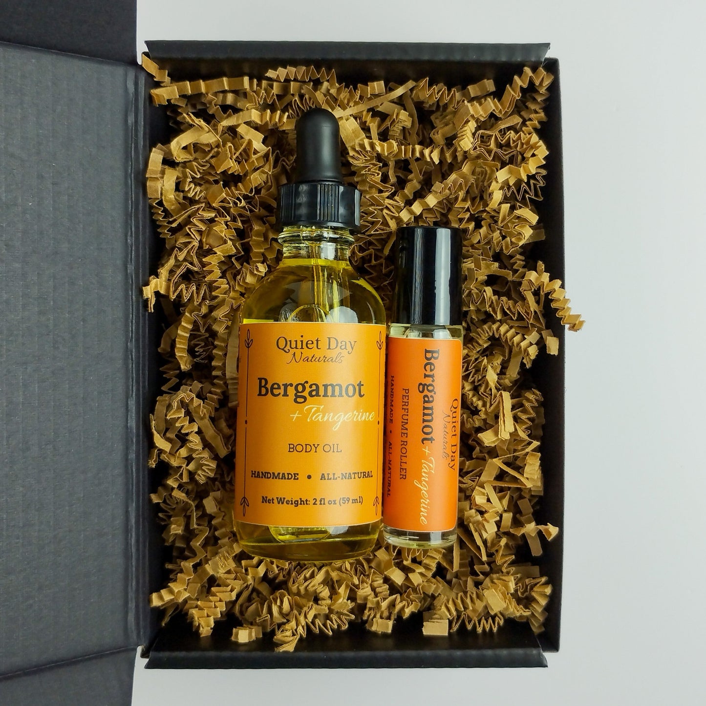 Closeup of Bergamot + Tangerine Body Oil and Perfume Roller Gift Set.