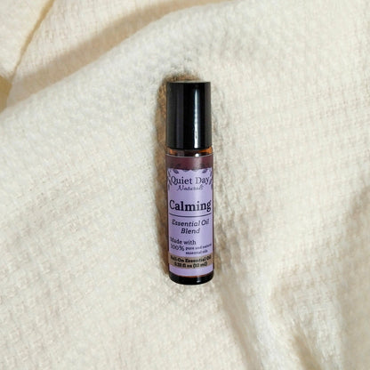 Calming Essential Oil Roller laying on a white blanket.