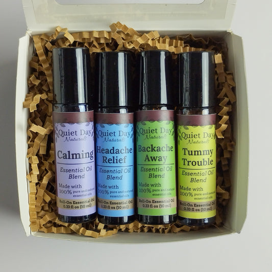 Closeup of Essential Oil Roller Variety Pack including Calming, Headache Relief, Backache Away, and Tummy Trouble Roll-Ons.