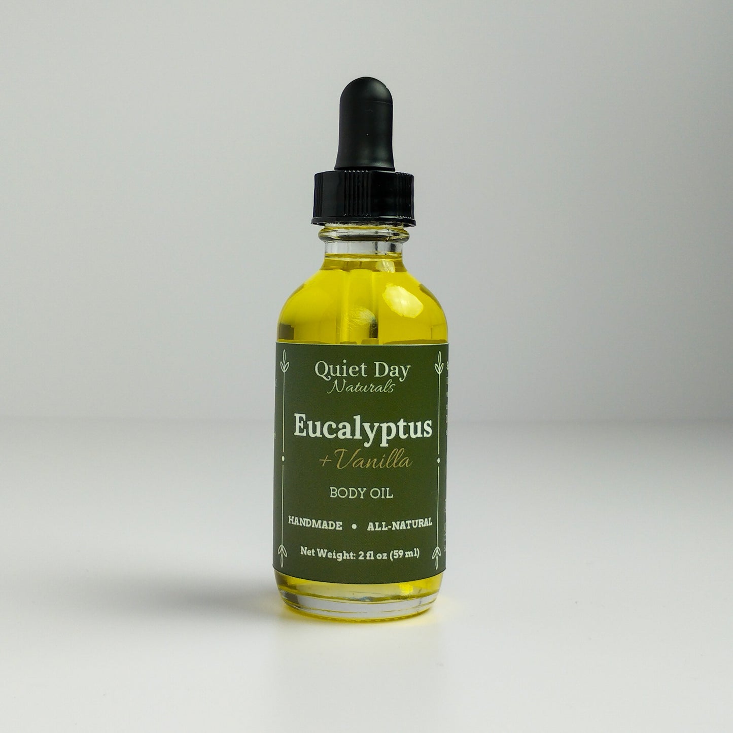 Eucalyptus and Vanilla Body Oil in a 2oz glass bottle with dropper standing against a white background.