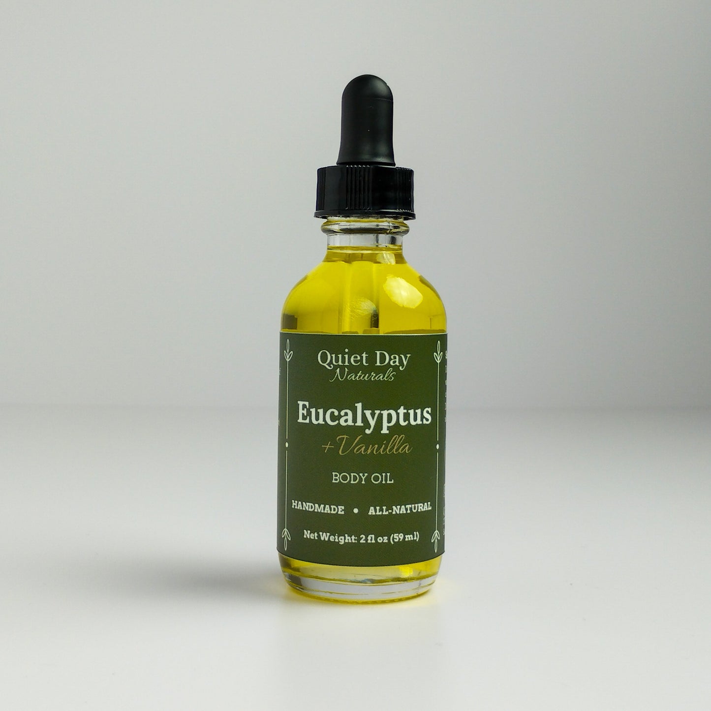 Eucalyptus and Vanilla Body Oil in a 2oz glass bottle with dropper standing against a white background.