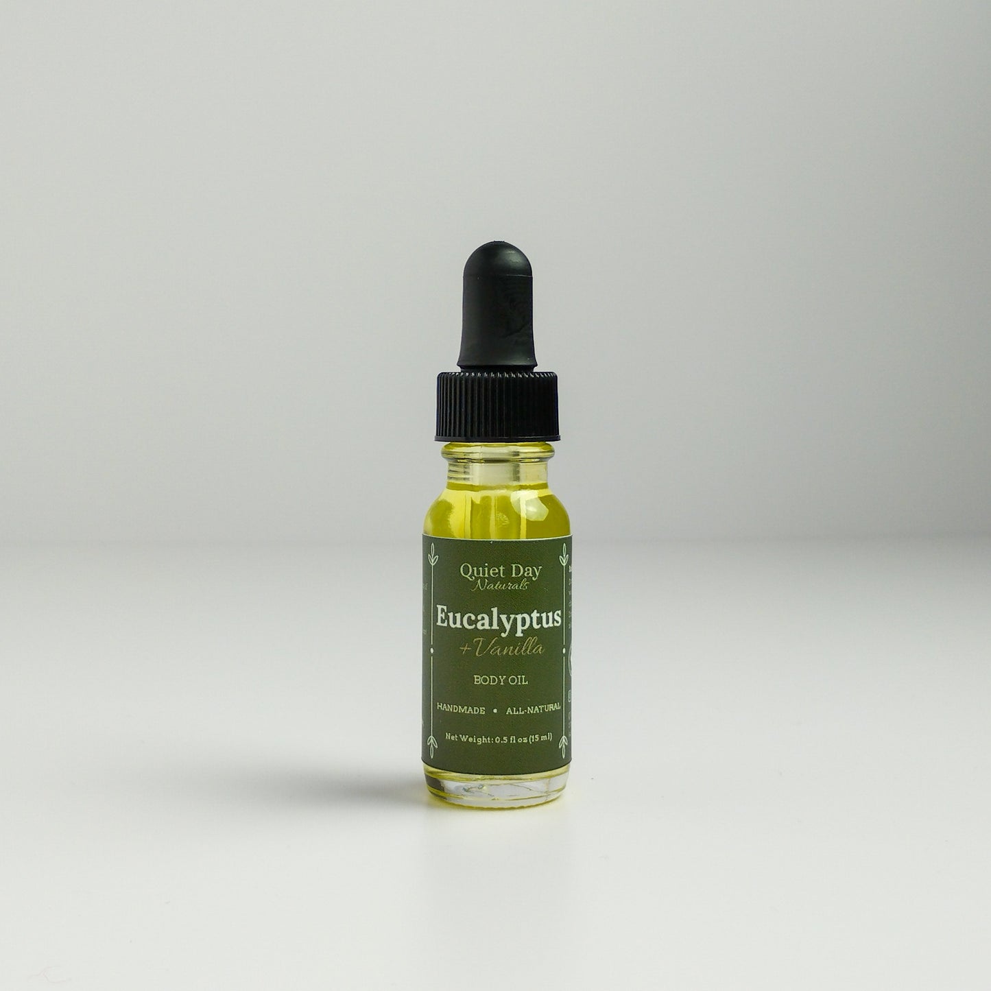 Eucalyptus and Vanilla Body Oil in a 0.5oz sampler glass bottle with dropper standing against a white background.