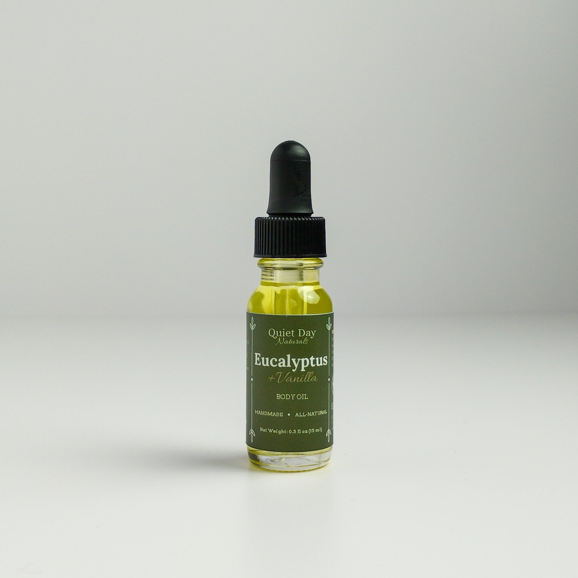 Eucalyptus and Vanilla Body Oil in a 0.5oz sampler glass bottle with dropper standing against a white background.