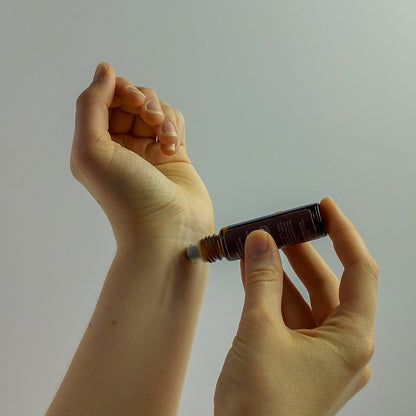 Handmade essential oil roller being applied to wrist.