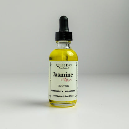 Jasmine and Rose Body Oil in a 2oz glass bottle with dropper standing against a white background.